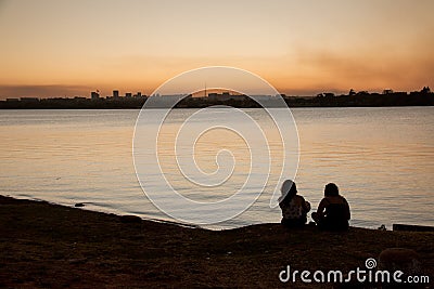 Two Ladies Enjoying the Sunset a the Lake Stock Photo