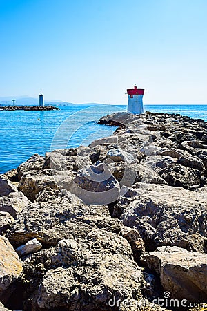 Two lighthouses located on the rocks of the breakwaters that protect the entrance to the marina Stock Photo