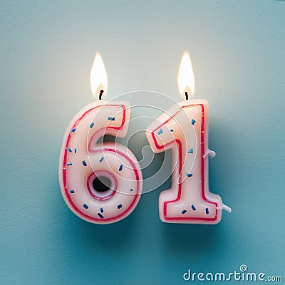 Two lit candles shaped like 61, white with pink outlines and blue specks Stock Photo