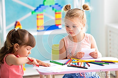 Two little beautiful girls draw with colorful pencils Stock Photo