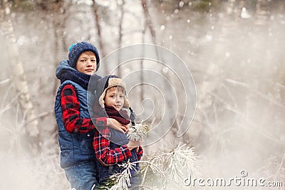 Two little boys friends hugging in winter forest. Brother love. Concept friendship Stock Photo