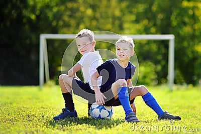 Two little brothers having fun playing a soccer game Stock Photo