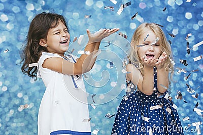 Two little girls child fashion with silver confetti in the background with patches of cute and beautiful Stock Photo