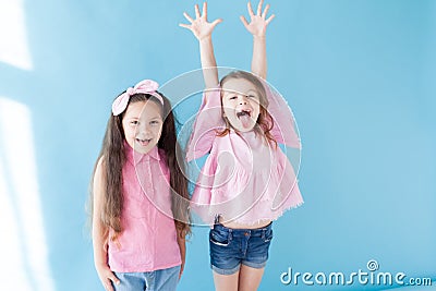 Two little girls in pink clothing girlfriends laugh Stock Photo