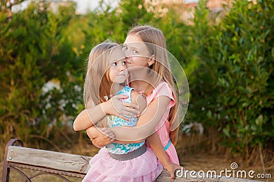 Two little girls sisters hugging and having fun in park. Stock Photo