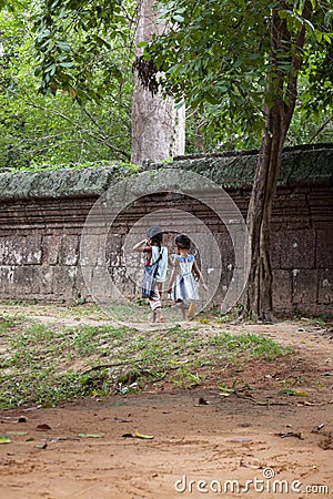 Two little girls walking along a stone wall Editorial Stock Photo