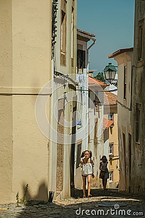 Two little girls walking up the alley on slope with old houses Editorial Stock Photo