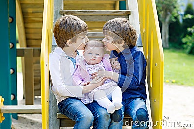 Two little happy kid boys with newborn baby girl, cute sister. Stock Photo