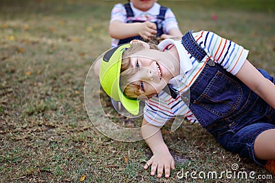 Two little kids boys having fun in a park, happy best friends playing, friendship concept. Siblings brothers, twins in Stock Photo
