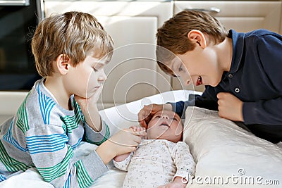 Two little kids boys playing with newborn baby sister girl Stock Photo