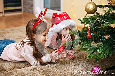 Two little sisters write the letter to Santa under the Christmas tree Stock Photo