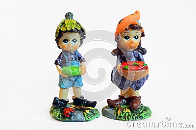 Two little statuette - boy and girl in garden with vegetables in hand - toys figurine - white background Stock Photo