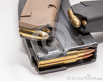 Two loaded 9mm pistol magazines with a loaded 223 caliber magazine Stock Photo