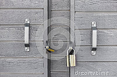 Two locks on a wooden grey door Stock Photo