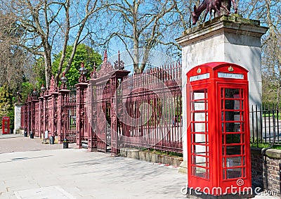 Two London bright red phone cabins infront big door Stock Photo