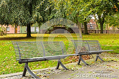 Two lonely benches in the city park under the rain Stock Photo