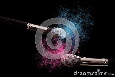 Two make up brushes with powder explosion dust in blue and purple color Stock Photo