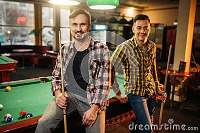 Two male billiard players with cues poses Stock Photo