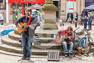 Two Male busker playing guitars and singing at the Lymelight Festival.. Editorial Stock Photo