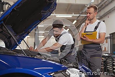 Two male mechanics working at the garage Stock Photo