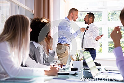 Two Male Colleagues Fighting In Office Stock Photo