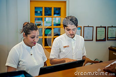 Two male and female receptionists on duty at the tropical resort Editorial Stock Photo