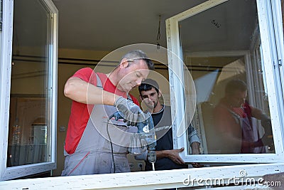 Windows installation worker with a drill Editorial Stock Photo