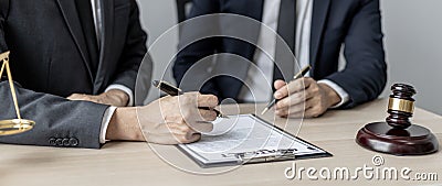 Two male lawyers are consulting together to draft a contract acknowledgment for their clients. Stock Photo