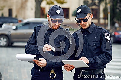 Two male police officers inspect car parking Stock Photo