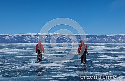 Two male tourists walk on frozen Baikal lake,Russia Editorial Stock Photo