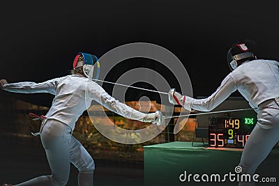 Two man fencing athlete fight on professional sports arena Editorial Stock Photo