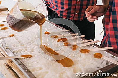 Two man pouring maple syrup on ice Stock Photo