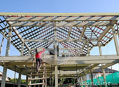 two man worker moving lift roof tiles on stair to second floor for prepare install building house roofs Editorial Stock Photo