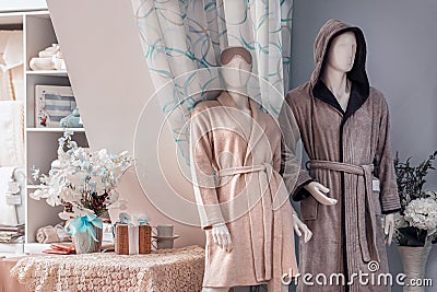 Two mannequins, a man and a woman a married couple in home clothes pajamas, in a home warm and cozy interior. shop Stock Photo