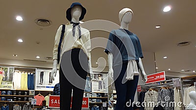 two mannequins wearing the latest clothes in Uniqlo Clothing store Editorial Stock Photo