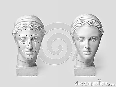 Two marble heads of young women, ancient Greek goddess bust marked with lines for plastic surgery and sculpture after Stock Photo