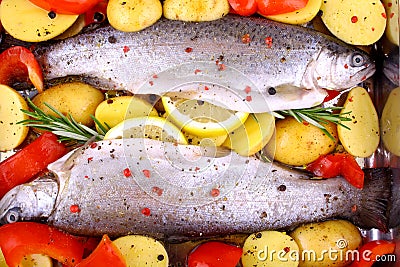 Two marinated rainbow trout with potato, red pepper and lemon Stock Photo