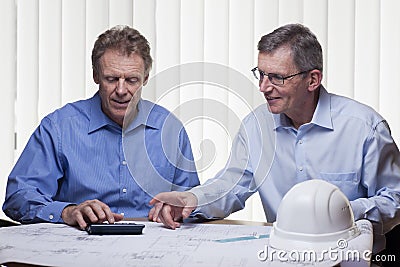 Two mature architects or engineers calcutating a project Stock Photo