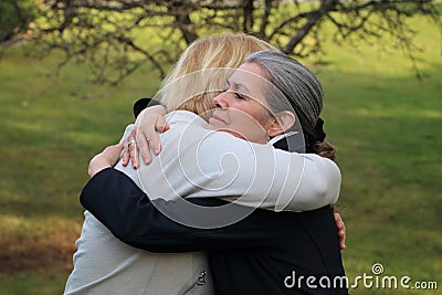 Two mature friends hugging Stock Photo