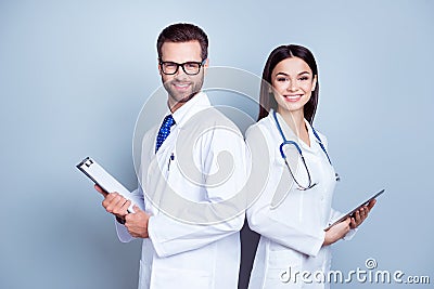 Two medic colleagues in white coats on pure background, holding Stock Photo