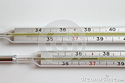 Two medical thermometers to measure the tempetature, one of them with a tempetature . Stock Photo