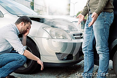 Two men arguing after a car accident on the road Stock Photo