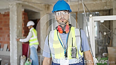 Two men builders standing with relaxed expressiona at construction site Stock Photo