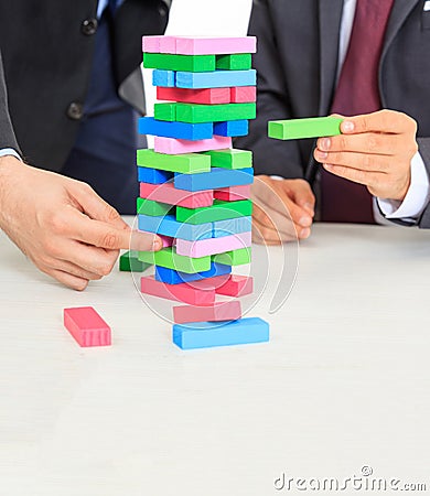 Two men and colorful blocks tower on a white office desk Stock Photo