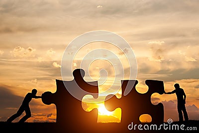 Two men connect two puzzle pieces. Concept of business solution, solving a problem. Stock Photo