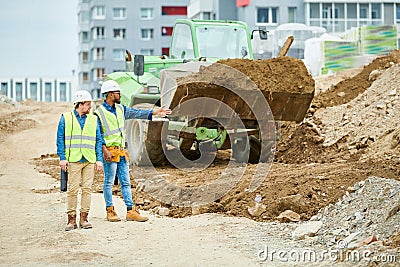 Building inspectors watching excavation process Stock Photo