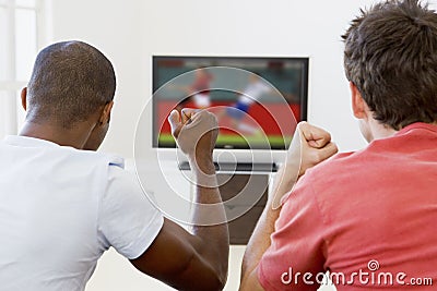 Two men in living room watching television Stock Photo