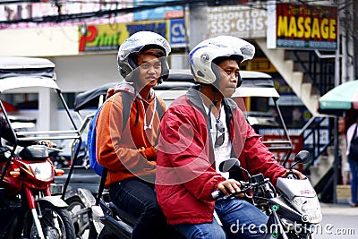 Two men riding in tandem on a motorcycle in Antipolo City. Editorial Stock Photo