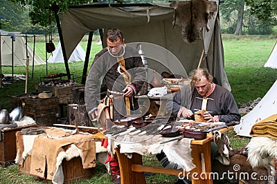 Two men selling armour, helmets and swords at the re-enactment of the Battle of Hastings in the UK Editorial Stock Photo