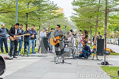 Two men of Shenzhen local street band palying guitar and singing at the Central park of Shenhzhen Editorial Stock Photo